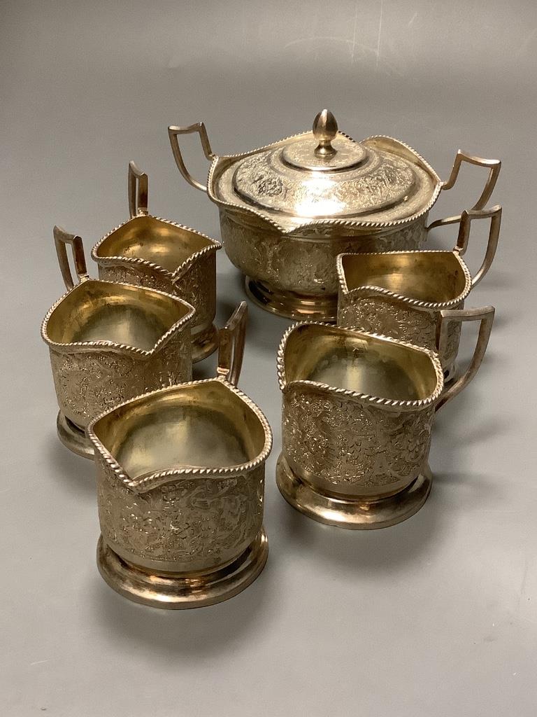 A Persian white metal sugar bowl and cover and five matching tea glass holders